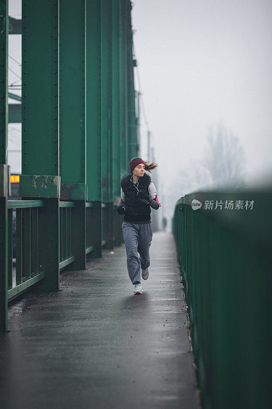 年轻女子在恶劣的天气条件下跑步和锻炼