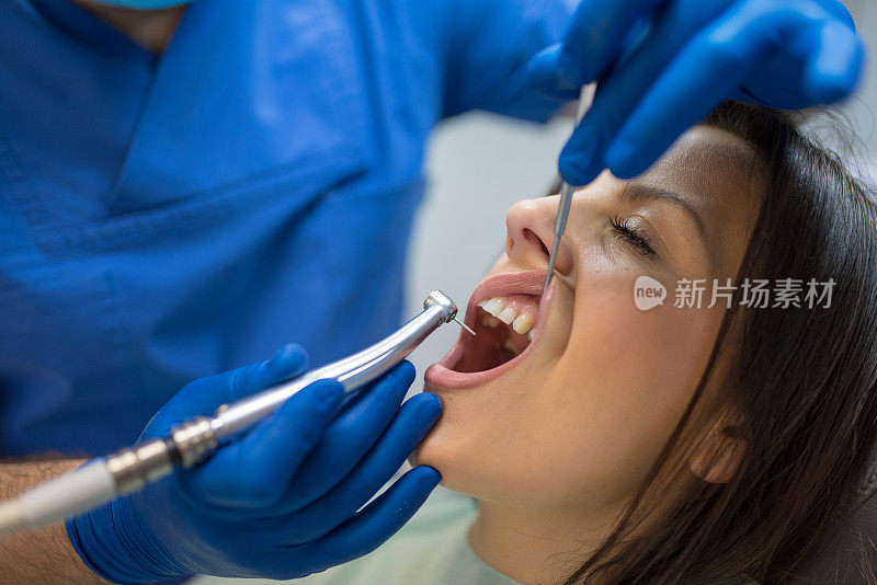 牙科医生戴上防护口罩和手套修复牙齿