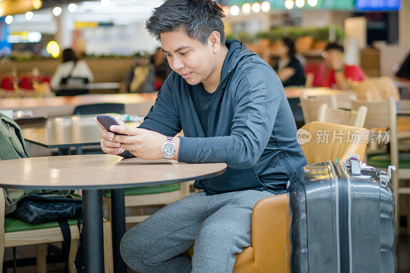年轻的日本亚裔男子乘坐公共交通工具，在日本机场等待飞机