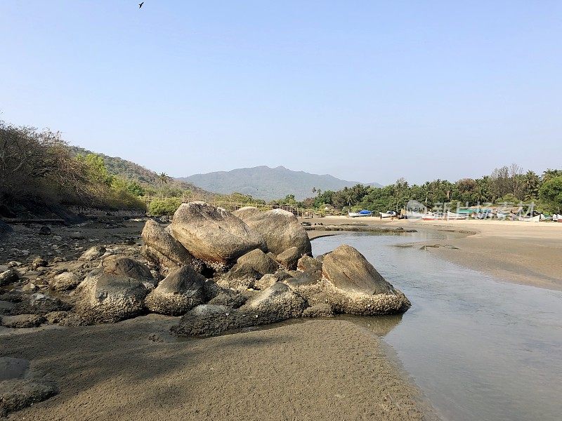 光滑的海滩巨石和岩石的图像，从海浪的海岸水力磨损侵蚀多年来，热带海滩度假天堂的印度度假天然岩石池和海岸流，帕洛伦海滩，果阿，南印度