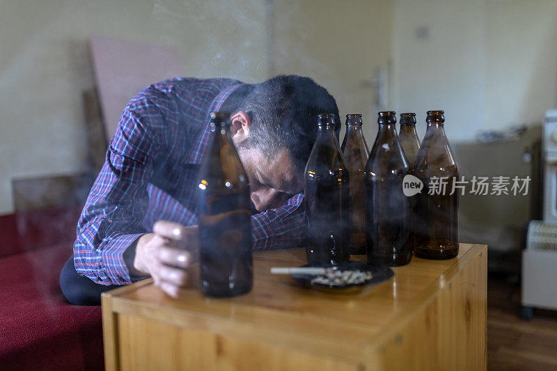 年轻悲伤的醉酒男子喝啤酒和酒精感到浪费，孤独和绝望的痛苦和情绪压力。人与酗酒、上瘾和男人抑郁的概念。