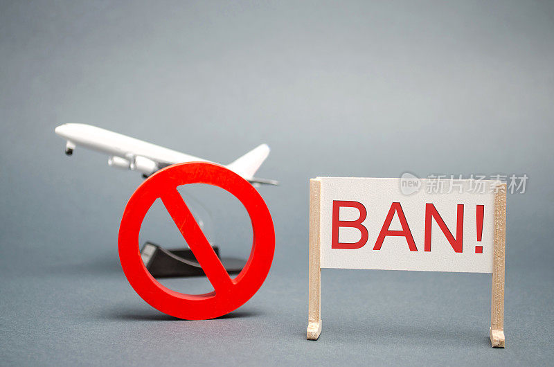 一张写有“Ban”字样的海报。禁令的标志和一个微型玩具飞机。禁止民用航空器飞行。禁区。停止标志。禁止机场建设。飞机。禁止
