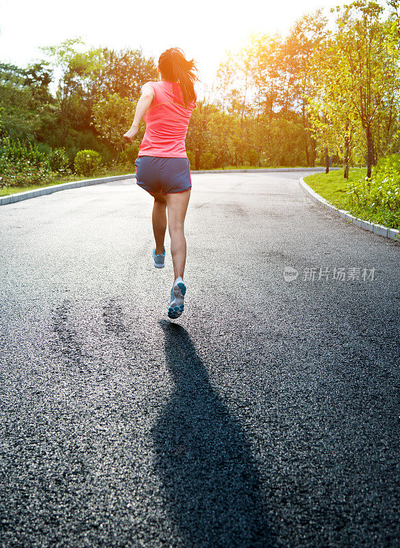 年轻的亚洲女人在公园慢跑