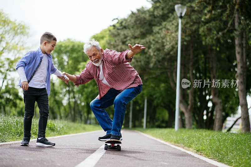 爷爷和孙子一起玩滑板