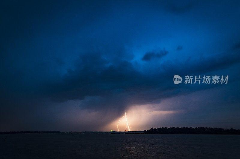 夏天湖面上黑暗夜空中的闪电