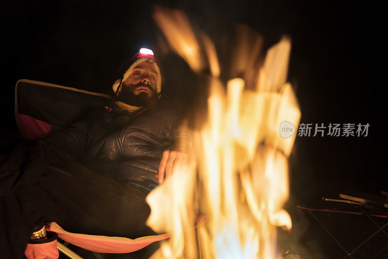 男人在树林里用篝火取暖