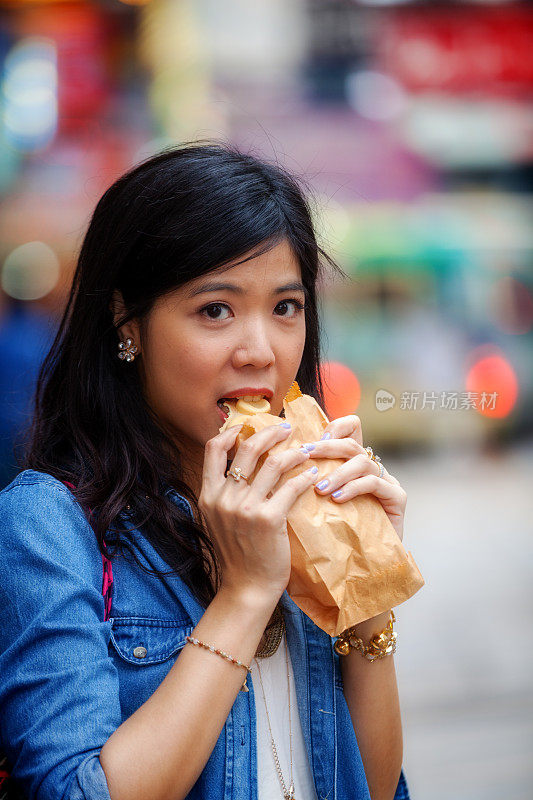 年轻的亚洲女人吃蛋华夫饼