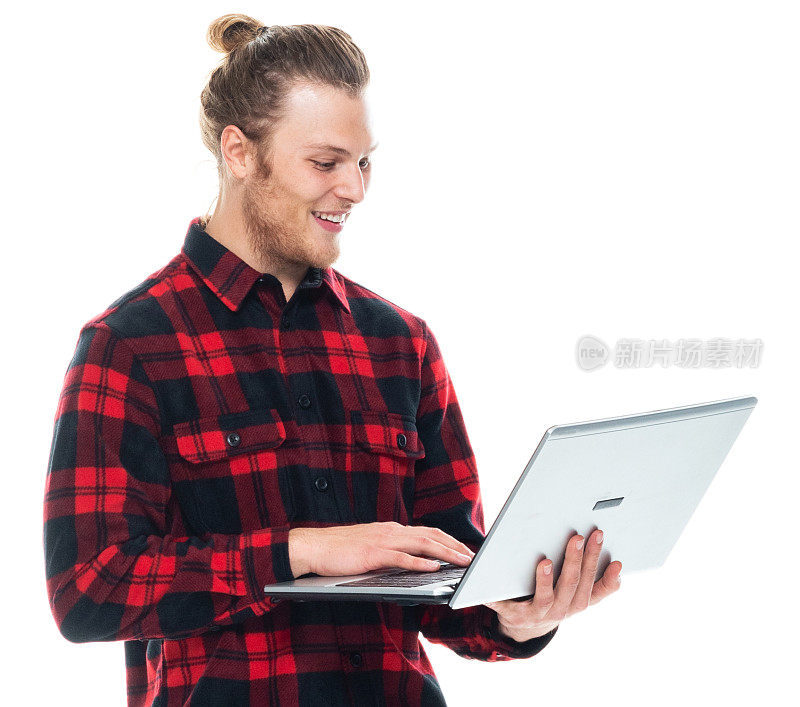 白人男性穿着衬衫站着用笔记本电脑