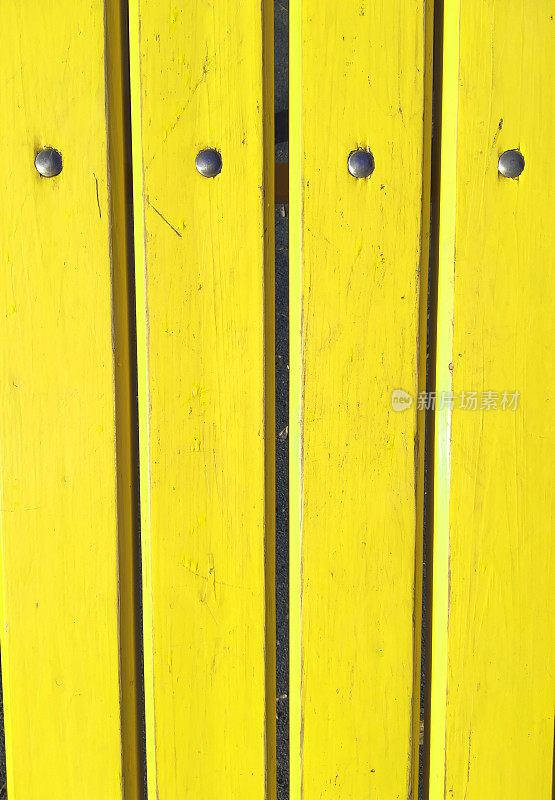 木板涂上黄色油漆，木栅栏带金属铆钉，墙壁，垂直背景
