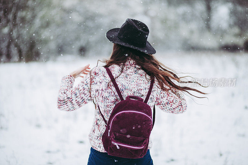 在雪地里伸出双臂的女人