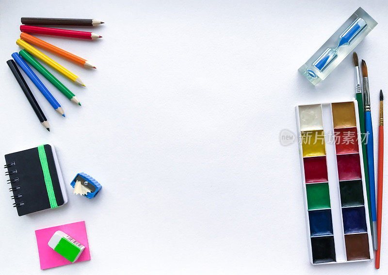 文具学校和创意，绘画和工艺品(水彩画颜料，彩色铅笔，笔记本，沙漏)与白色水彩纸上的文字空间