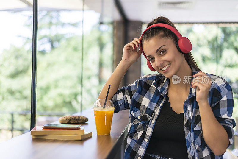 一个漂亮的女人用耳机听手机里的音乐