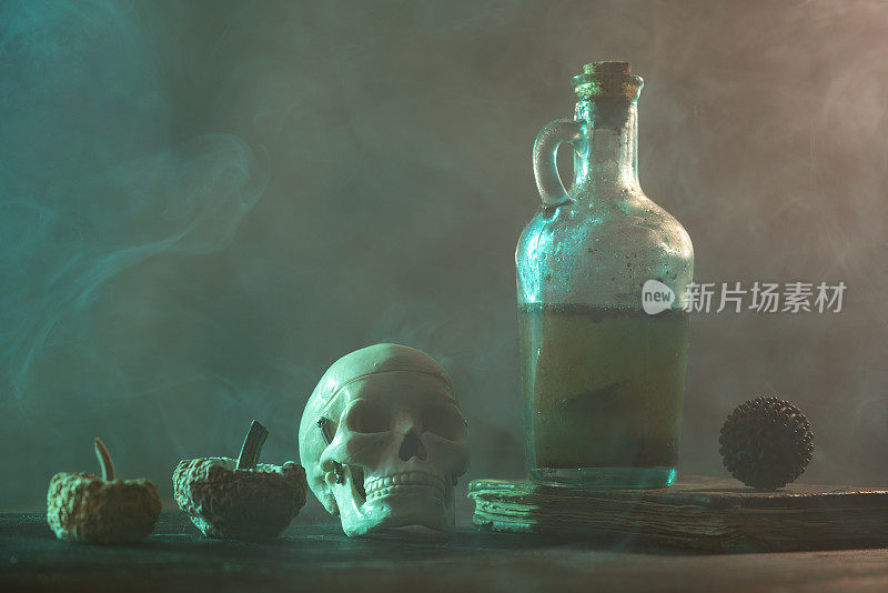 人的头骨，腐烂的南瓜，魔法书，病毒形状的物体和雾中的毒瓶