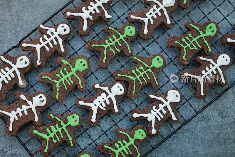 想象一下，一排排自制的人形巧克力饼干放在烤架上，上面是防油的羊皮纸烘焙纸，饼干用绿色和白色的糖霜冰冻成骷髅，从高处俯瞰，万圣节主题的派对食品
