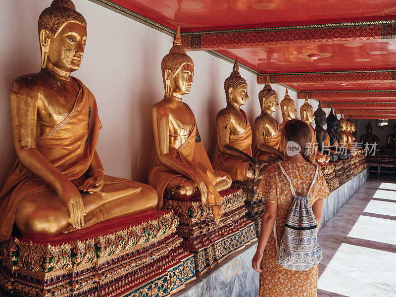 一名妇女在泰国参观有佛像的寺庙