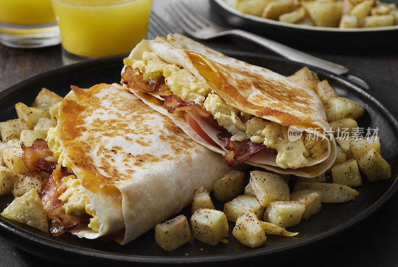 折叠早餐玉米饼，炒鸡蛋，培根，番茄和奶酪