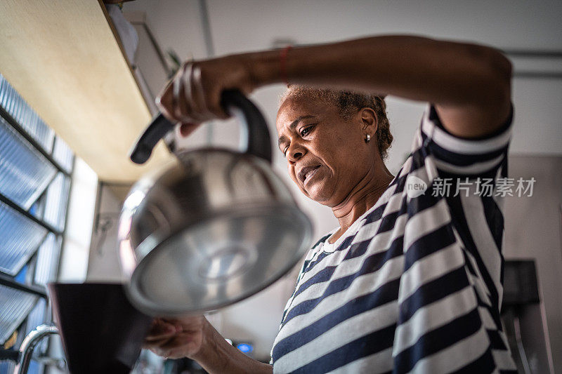 在家里煮咖啡的成熟女人