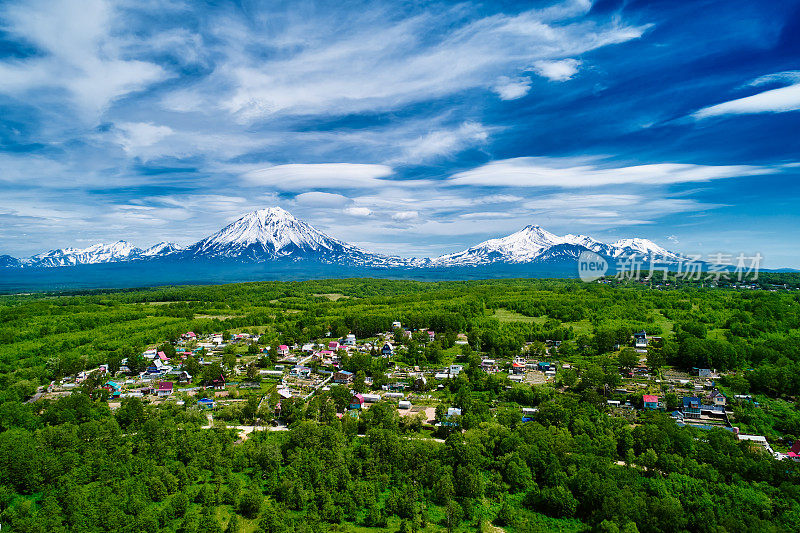 Avachinsky和Koryaksky火山的无人机视图与一个村庄在前景