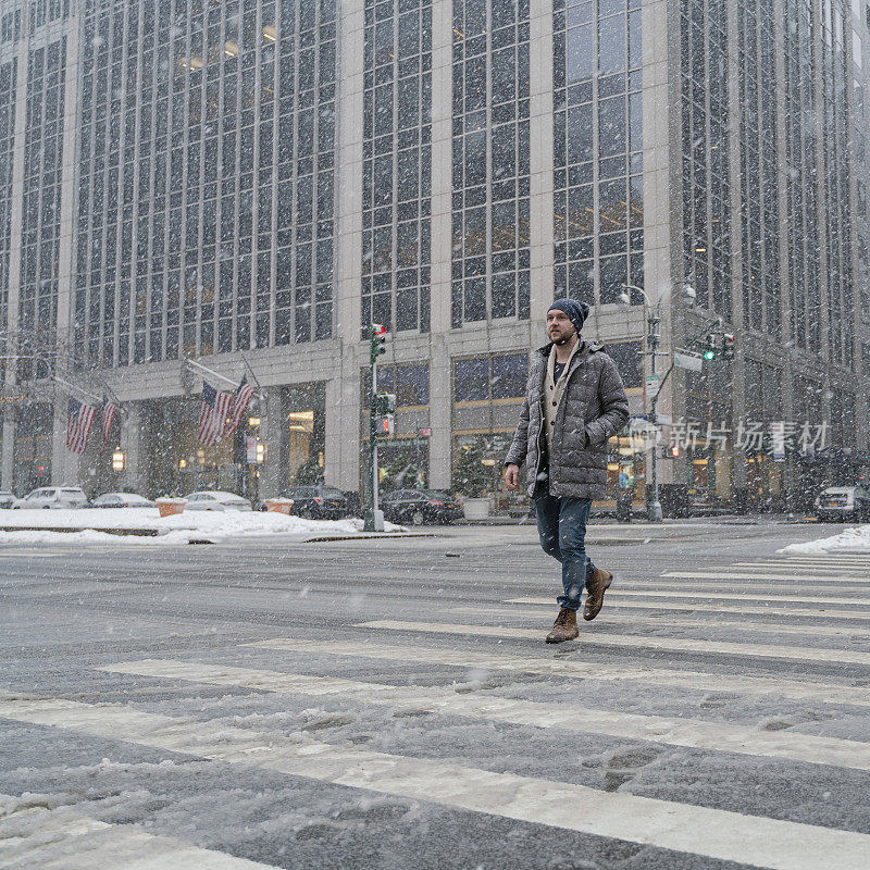 一名年轻游客，在一场大雪中穿过曼哈顿的街道