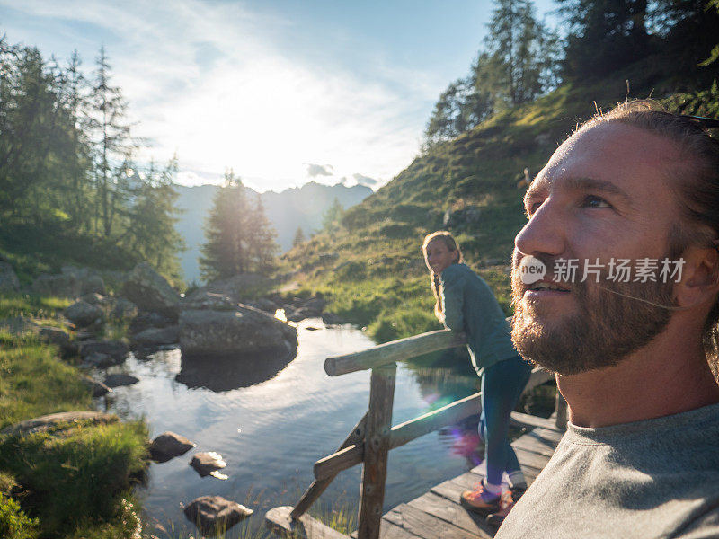 日出时分，一对情侣在湖边码头上休息