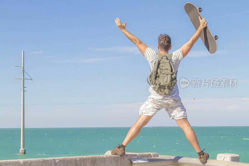 一个年轻的滑冰男子在一个炎热的阳光灿烂的夏天在美国佛罗里达的基韦斯特旅行