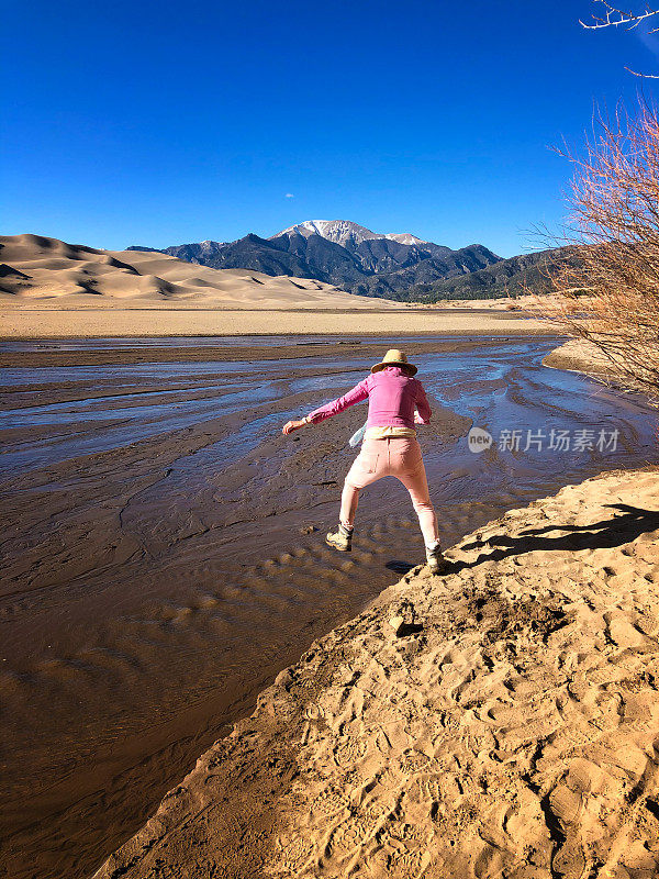 妇女跳过水，大沙丘科罗拉多