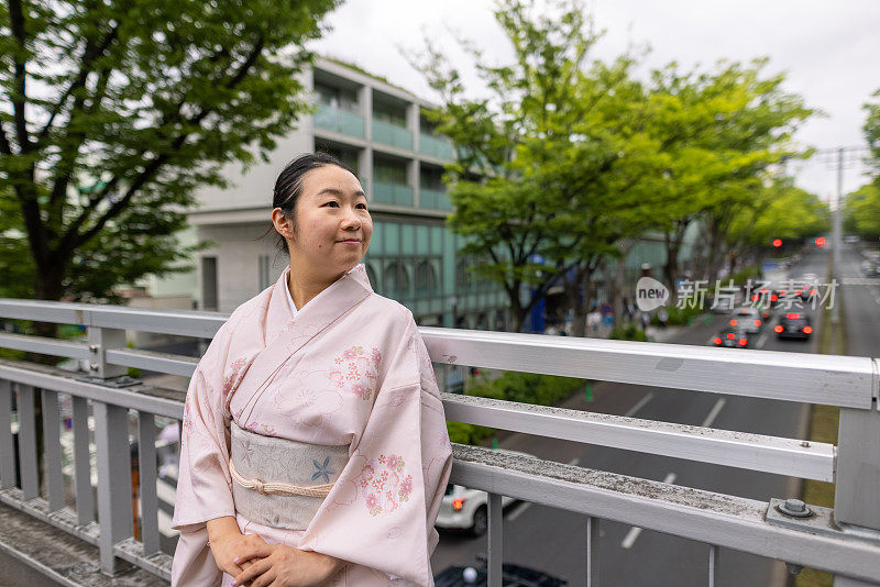 穿着和服的女人站在人行桥上