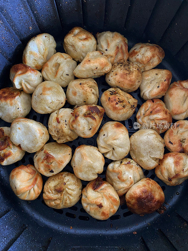 Momos(南亚饺子)图片，白面粉和水面团，填满鸡肉和混合蔬菜，在空气炸锅中烹饪，比煎锅更健康的选择，高架视野