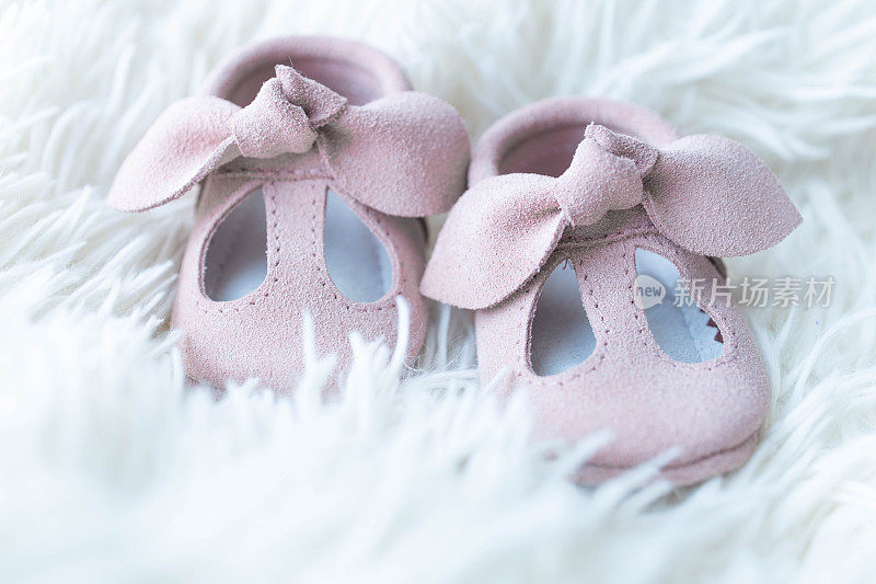 桌子上放着为未出生婴儿准备的粉红色小鞋子