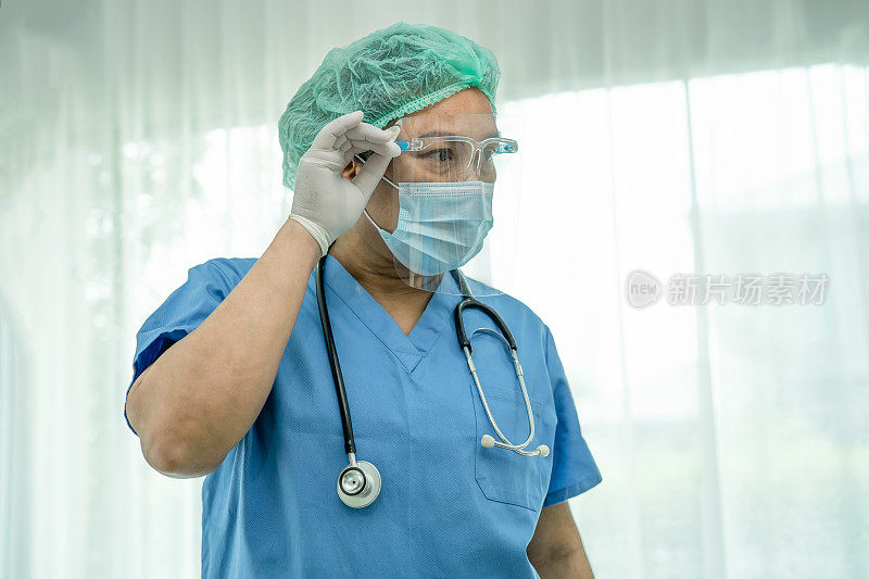 亚洲医生穿戴面罩和个人防护服检查患者防护安全新常态感染新冠肺炎疫情在隔离护理医院病房爆发。