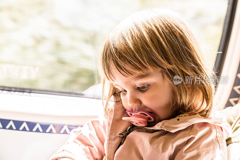 坐火车时坐在窗边的小女孩。