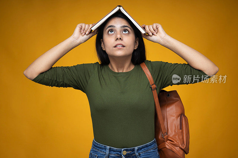 年轻的印度女人在黄色拷贝空间背景库存照片