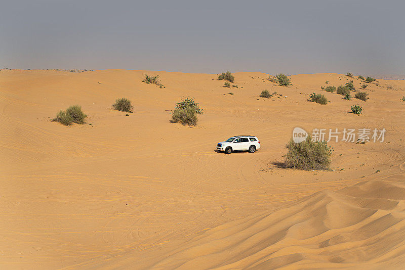 一辆四轮驱动汽车行驶在阿拉伯联合酋长国的迪拜沙漠