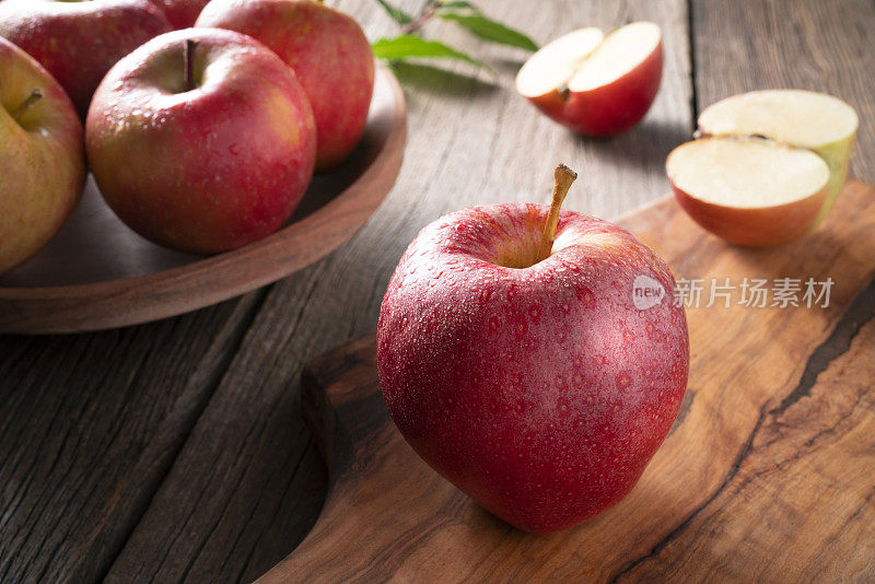 红苹果皇家晚会特写湿漉漉的露珠在砧板和木桌上的刀