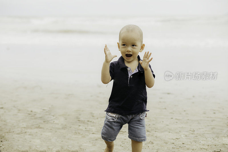 婴儿在海滩上散步，微笑着