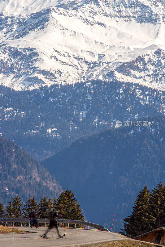法国阿尔卑斯山，一名男子穿着雪鞋穿过柏油路