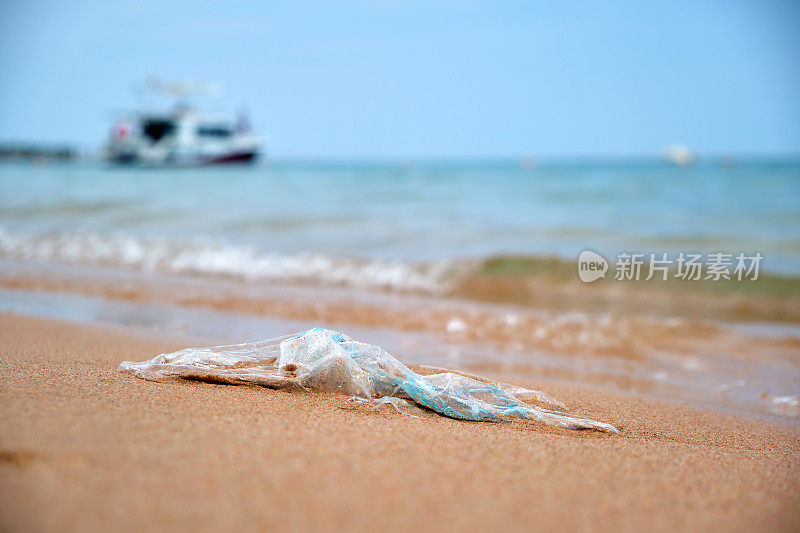 在沙滩上留下塑料袋垃圾。把用过的脏垃圾倒在海边。环境污染。生态问题