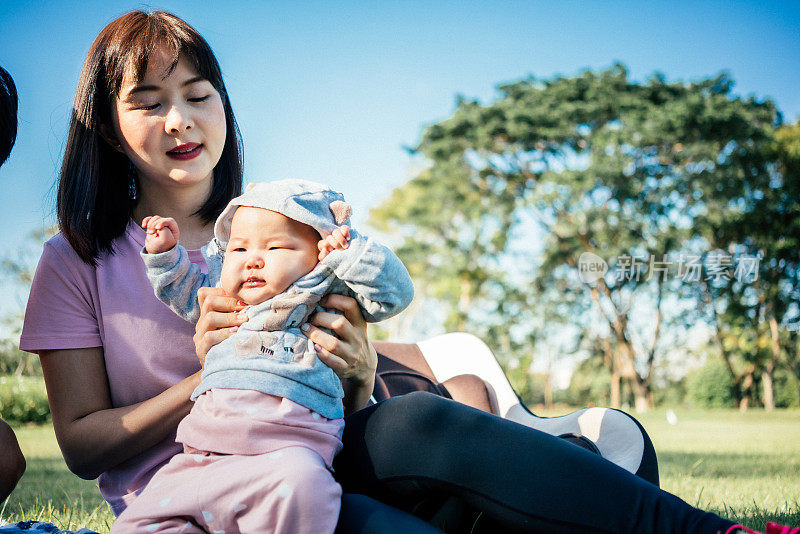 一位年轻的亚洲女性母亲抱着她美丽的女婴