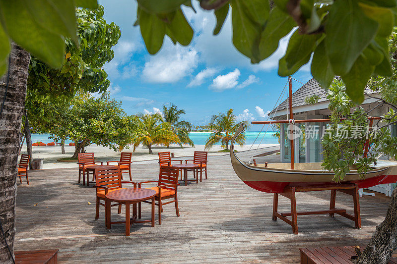 热带户外酒吧餐厅在海边的木甲板码头与绿松石泻湖