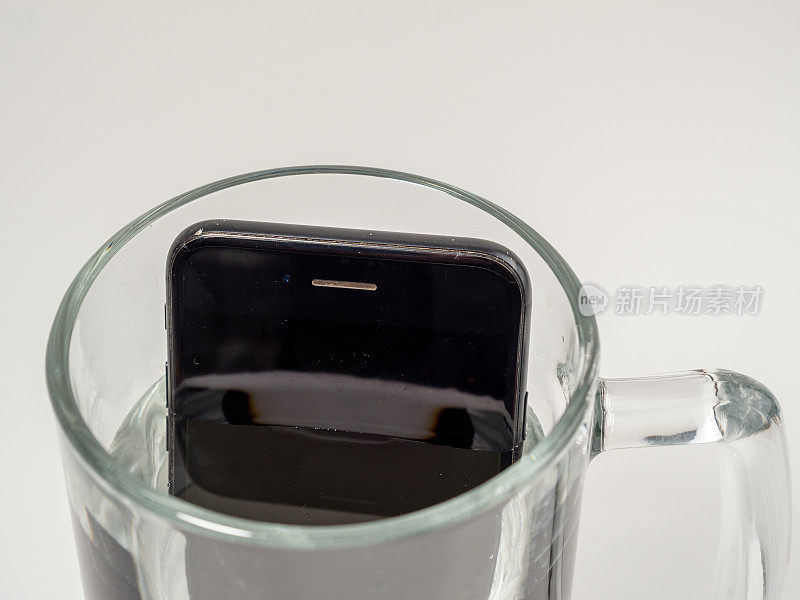 把智能手机放在一杯水里。智能手机掉进水里了。