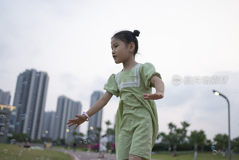 穿着绿色衣服的小女孩的城市户外生活