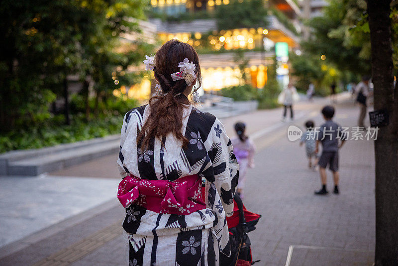 夏季节日时一家人在汤田走在街上的后景