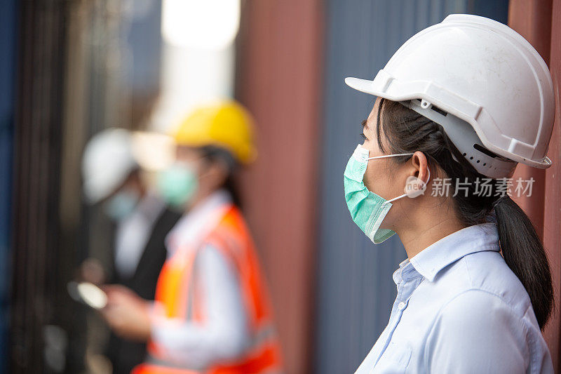 戴着防护口罩在物流货仓工作的亚洲女工。进出口经营理念