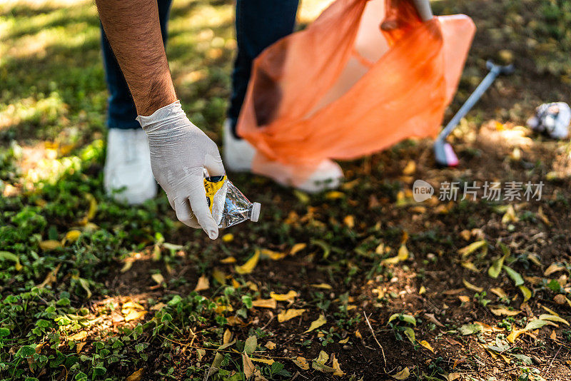 一个回收者在公园里收集垃圾的特写