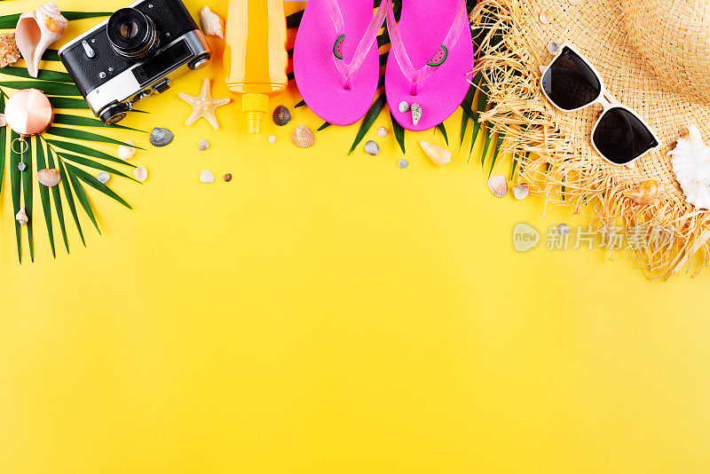 度假计划简单主题的休闲属性-草帽，太阳镜，人字拖，胶片相机和棕榈叶在统一的黄色背景平铺与复制空间