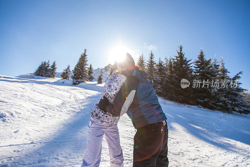 一对年轻的情侣在雪山上拥抱