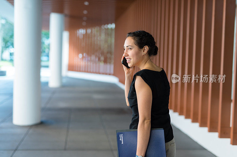 一位年轻的女商人在去开会的路上讲电话