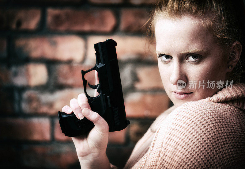 自信而冷静，一个漂亮的年轻女人拿着她的手枪