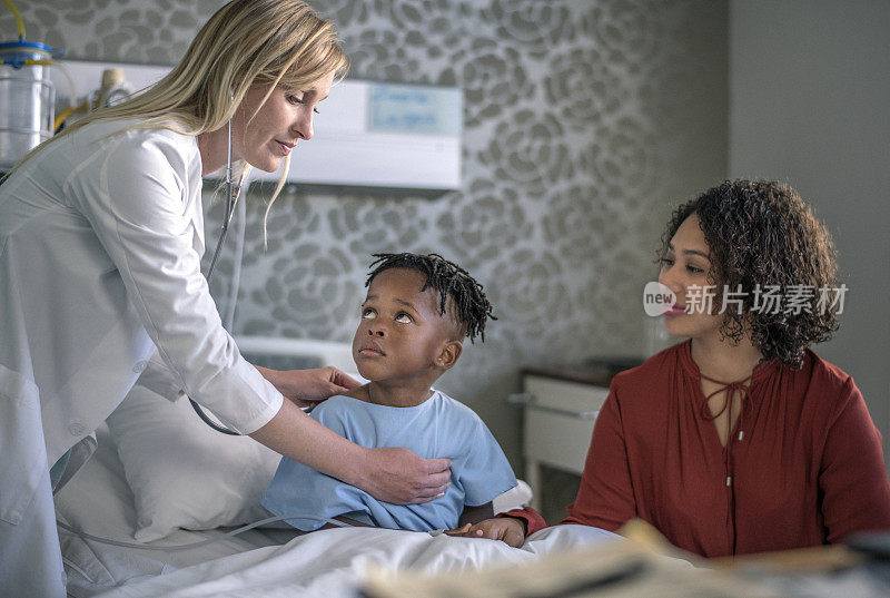 女医生由病房的母亲检查生病的男孩
