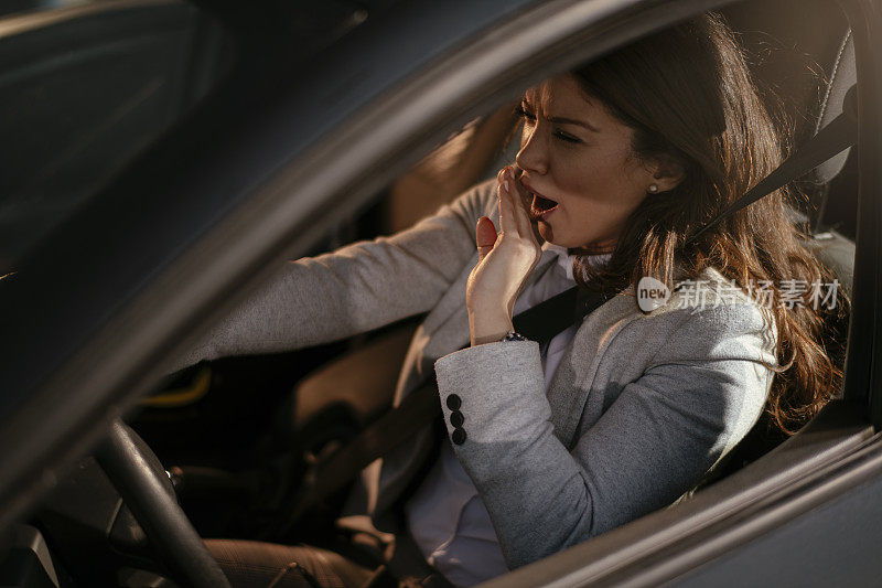 女商人开车累了昏昏欲睡的女商人开着她的车